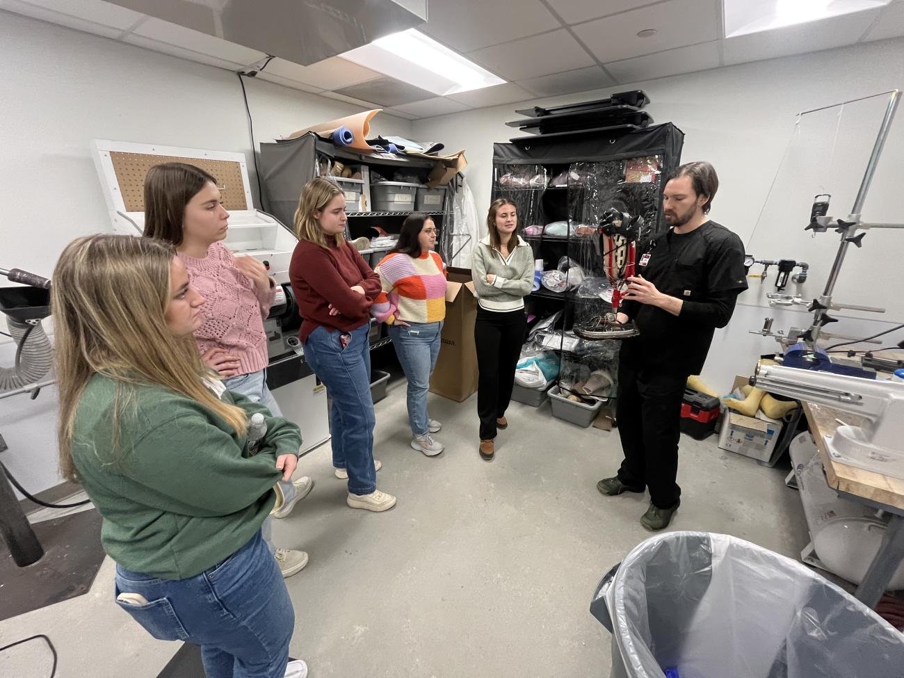 Ben Hogan and students stand in a semicircle to discuss the prosthetic.