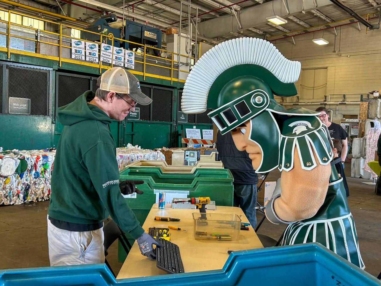 The Sparty Mascot inspects a keyboard with a SSRC employee