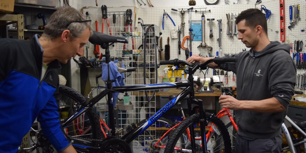Two MSU Bike employees make adjustments to a bike.