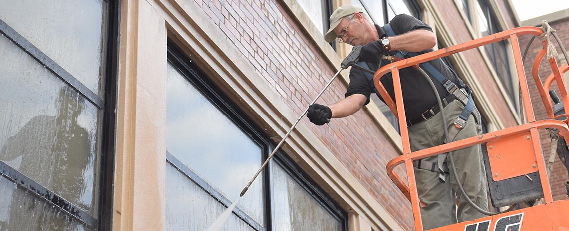 photo of ipf worker power washing parts of the psychology building