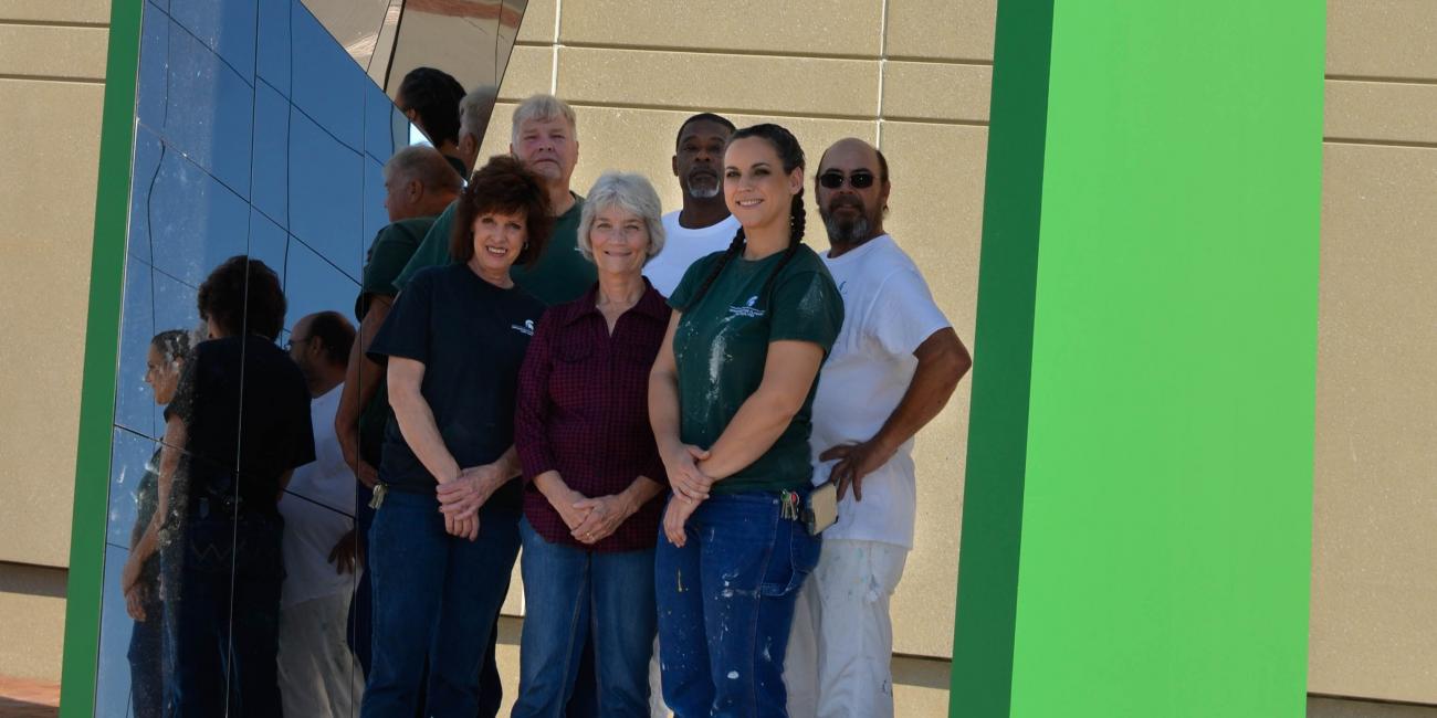 ipf painting crew standing inside of art installation at south end zone of spartan stadium