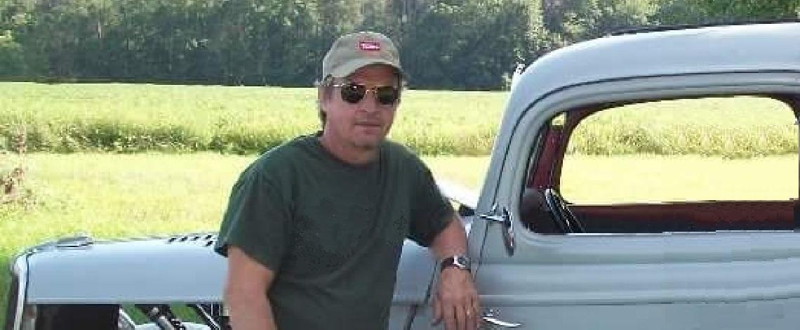 Doug Aves leaning against a vintage truck that he helped renovate