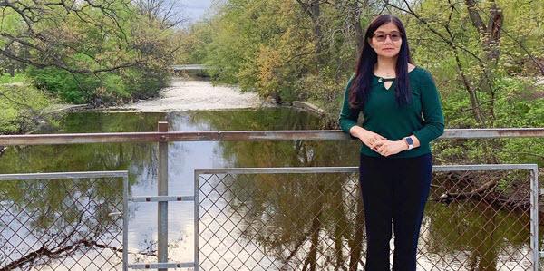 Photo of Yun Cao on bridge overlooking Red Cedar River