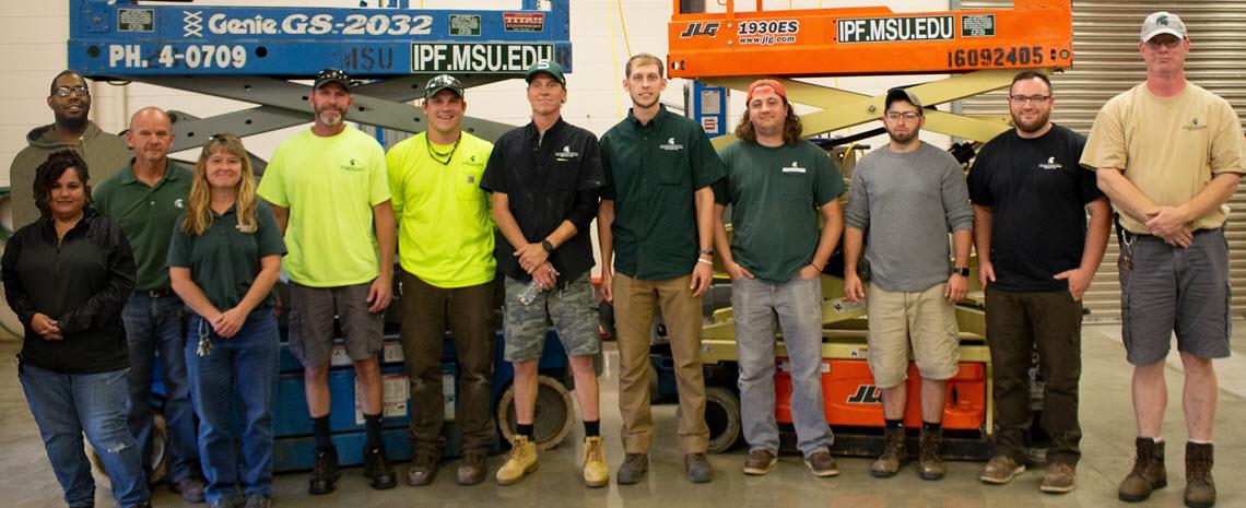 Set up crew standing inside building 209 in front of scissor lifts