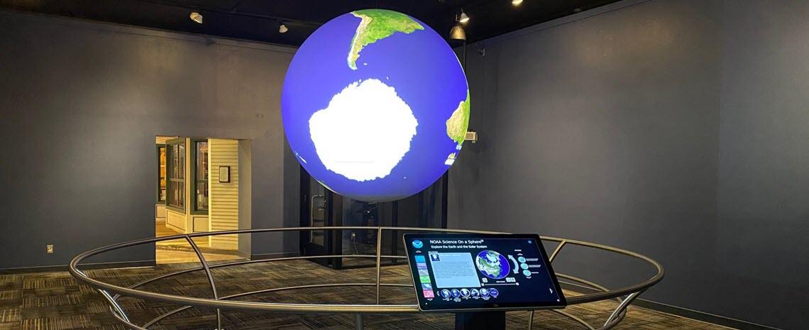 Photo of the Science on a Sphere exhibit showing the globe, podium and railing