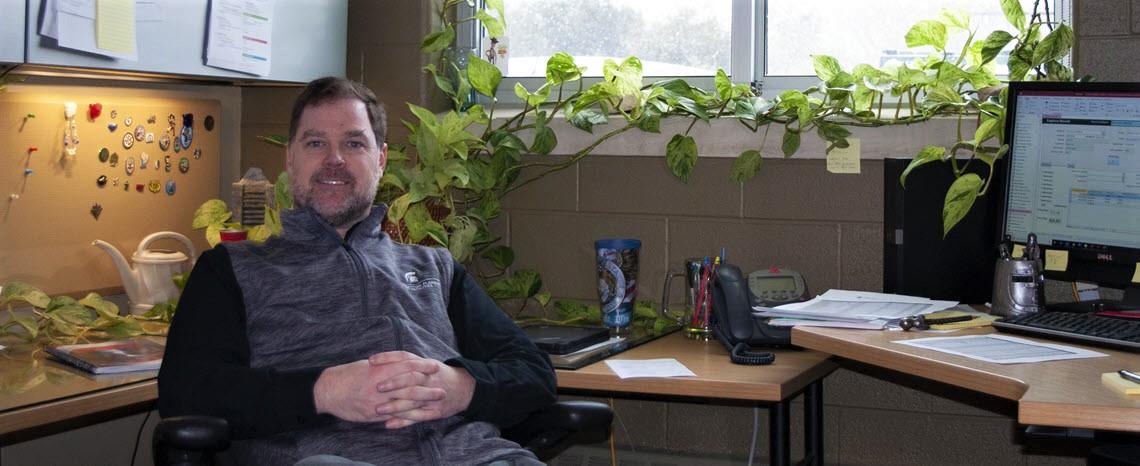 Photo of Josh Sego in his office surrounded by plants
