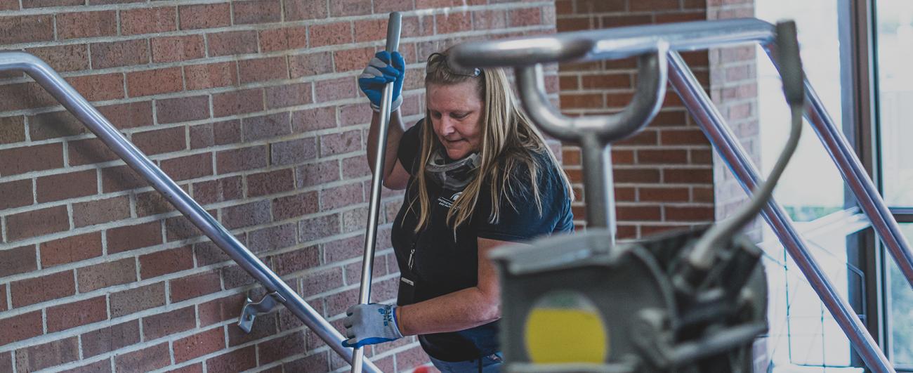 MSU Custodial Services employee cleaning stairs