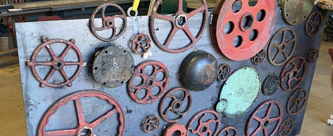 Artifacts from the Shaw Lane Power Plant welded to sheet metal and displayed as an art piece