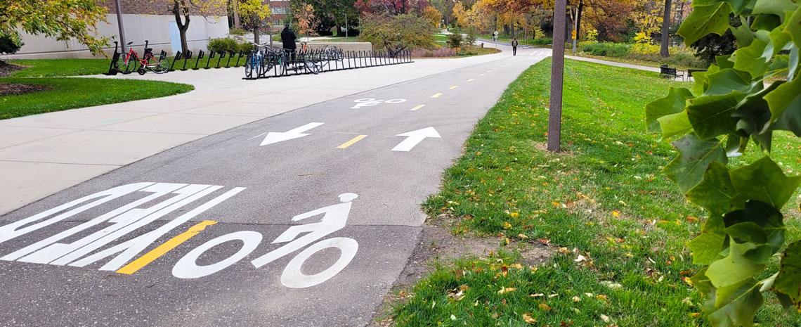 A concrete path with a bicycle painted on it, along with the word YIELD