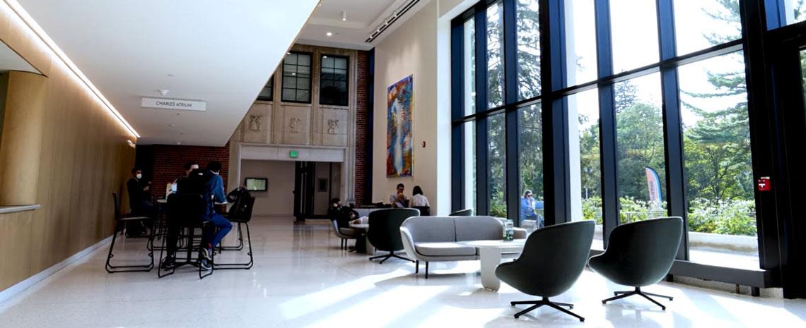 Interior of the Billman Music Pavilion with a wall of large windows and seating for students