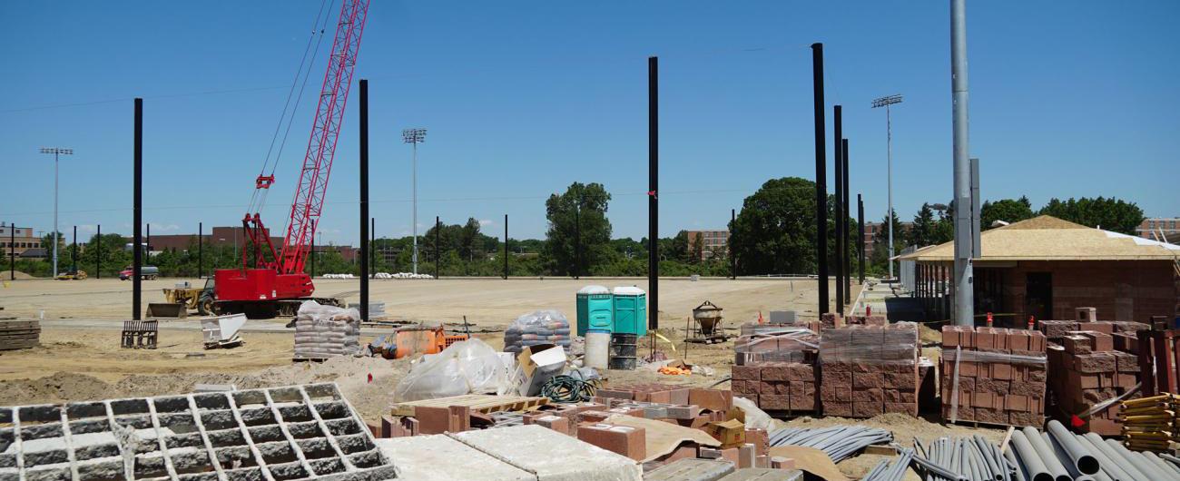 Photo of ongoing construction at Service Road Fields with a big open dirt space, cranes, cinder blocks, and construction equipment