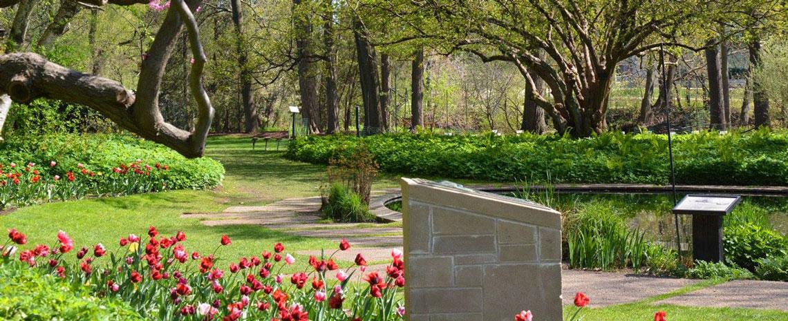 Beal garden on a spring day with red tulips in foreground