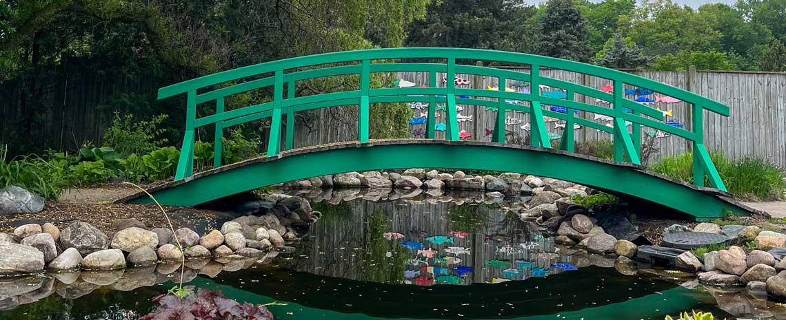 a small green bridge spans a gentle water feature