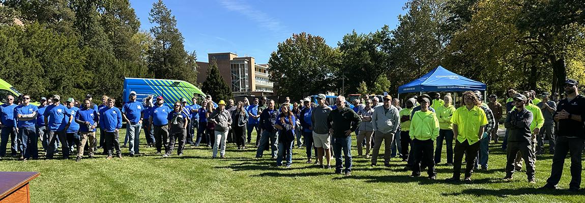 hundreds of volunteers gather in bright colored shirts to participate in the planting event