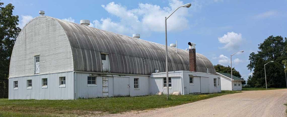 large white, domed farm building in disrepair